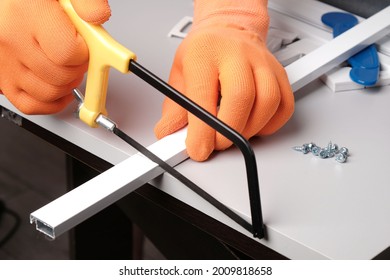 Assembling  mosquito net for  window,  master cuts an aluminum profile with  hacksaw