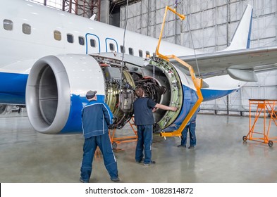 Assembling, Replacing Engine Parts Of The Plane After Repair. Specialist Mechanic Controls The Crane Of An Airplane. Concept Maintenance Of Aircraft