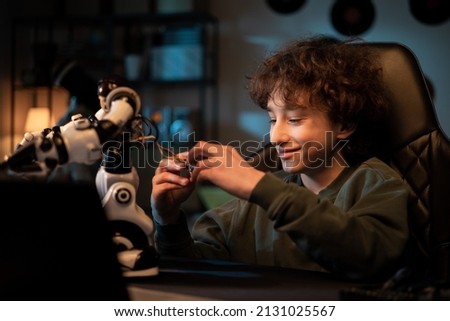 Assembling robot components. A child interested in robotics builds his own toy, pulls the cables, assembles the electronic control system.