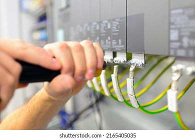 assembly components and cables in a factory in a control cabinet - workplace industry with future - closeup with hand and tools 