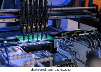 Assembly of computer circuit board - automatic SMD pick and place machine during work at factory. Automated technology, industrial, robotic, electronic, production, manufacturing concept