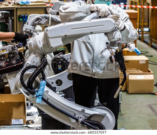 Assembly of industrial robots, People work with\
robots in industry.