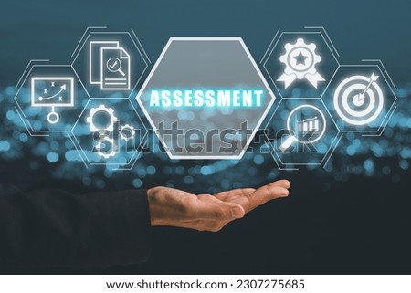 Assessment analysis Business analytics evaluation measure technology concept, Business person hand holding assessment icon on virtual screen.