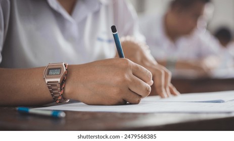 Assessment examination of high school students dressed in uniform.The students were doing the exams inside the classroom with stress - Powered by Shutterstock