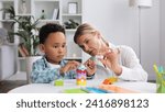 Assessment of mental development of children. Professional psychologist observes small multiracial boy playing with puzzle game, assessing his readiness for preschool. Exercises for kid with autism.