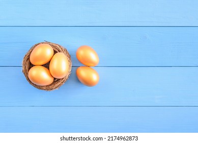 Asset Allocation For Growth, Sustainable Portfolio, Long-term Wealth Management With Risk Diversification, Financial Concept : Five Golden Eggs In A Bird Nest Or A Basket On Blue Wooden Background.