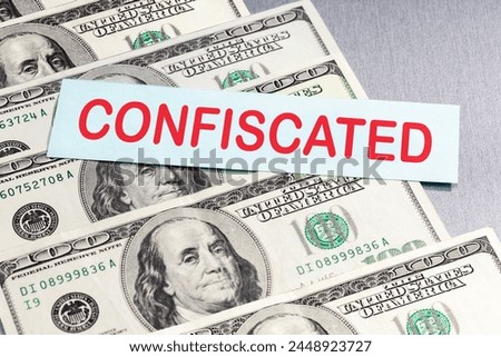  Asset freeze seizure. Economic sanctions, confiscation of funds. Dollar banknotest and list paper with CONFISCATED word.