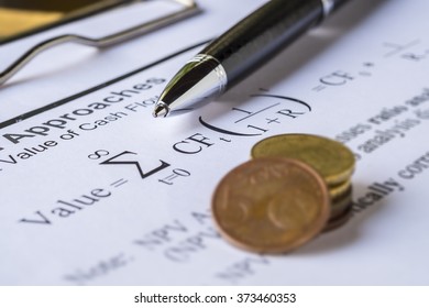 Asset Valuation Concept. Pen And Coins On Discount Cash Flow Model.