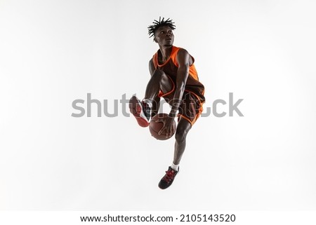 Assist. One young african man, professional basketball player training, practicing isolated over white studio background. Concept of professional sport, healthy lifestyle, motion and action