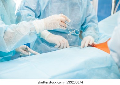 Assistant Adds Surgeon Instruments During Surgery, Close Up Of Hands In Glove Holding Scissors