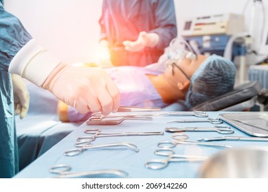 Assistant Hands out Instruments to Surgeons During Operation. Surgery and emergency concept