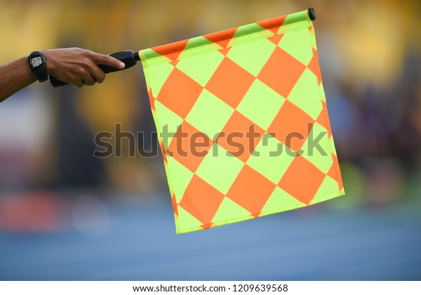 Assistant referee hold\
flag , offside signal
