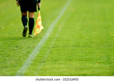 Assistant Referee Running Along The Sideline During A Soccer Match