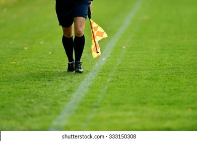 Assistant Referee Running Along The Sideline During A Soccer Match