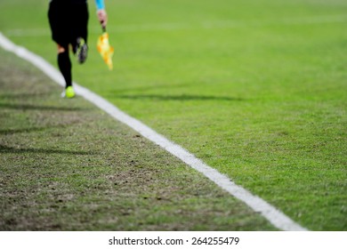 Assistant referees running along the sideline during a soccer match - Powered by Shutterstock