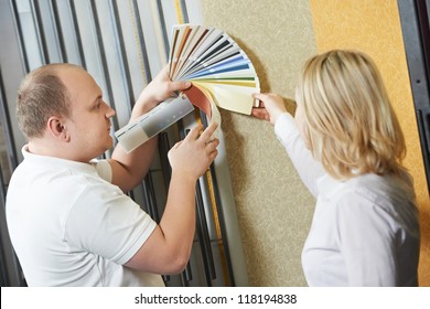 Assistant Seller Help Choosing Paint Color And Demonstrating Matching Samples To Buyer At Hardware Store