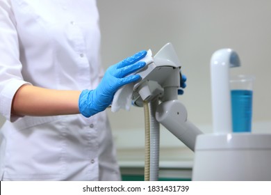 The assistant wipes the dental equipment with a wet cloth. Disinfection in the dental office. The concept of hygiene and sanitation. Preparing the office for receiving patients. Unrecognizable person.