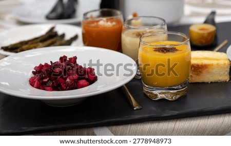 Assorted appetizers, including beet salad, gazpacho, and other small dishes, presented for tasting
