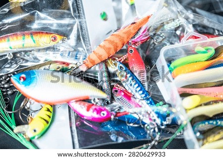 Assorted artificial baits including metal jigs and soft plastics for angling