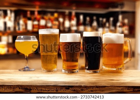 Assorted beer glasses lined up on a bar counter
Beer tasting selection with different styles and colors
Variety of craft beers served in glasses at the bar
