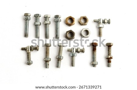 Assorted bolts and nuts organized in rows for classification isolated on white background
