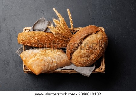 Assorted bread varieties in a charming basket, ready to be enjoyed. Flat lay