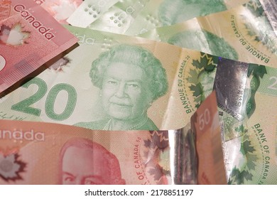 The assorted Canadian dollar bills with a Queen Elizabeth on 20 dollar bill, surrounded by other blurry bills
