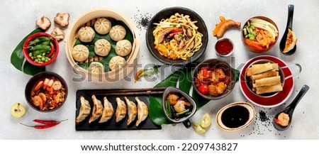 Assorted Chinese food on dark background. Chinese cuisine dishes on table. Asian food concept. Top view.