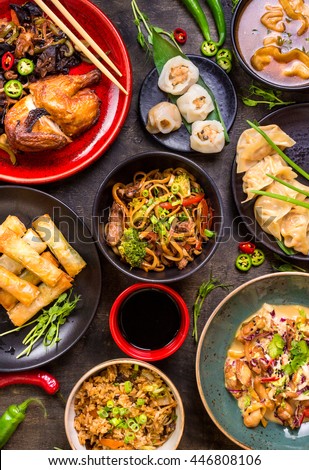 Assorted Chinese food set. Chinese noodles, fried rice, dumplings, peking duck, dim sum, spring rolls. Famous Chinese cuisine dishes on table. Top view. Chinese restaurant concept. Asian style banquet