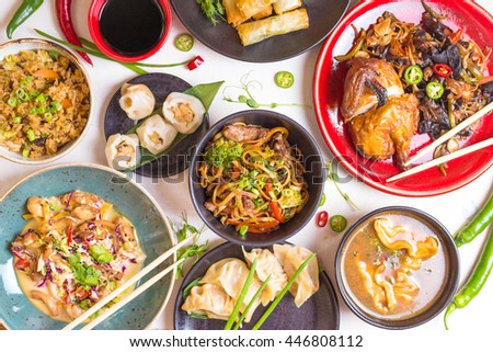 Assorted Chinese food set. Chinese noodles, fried rice, dumplings, peking duck, dim sum, spring rolls. Famous Chinese cuisine dishes on white table. Top view. Chinese restaurant concept. Asian style 