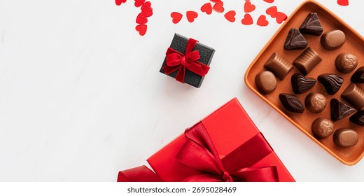 Assorted chocolates and gift boxes. Chocolates in a tray, gift boxes with red ribbons. Perfect for celebrations, chocolates and gifts convey love and joy. Christmas food photo.