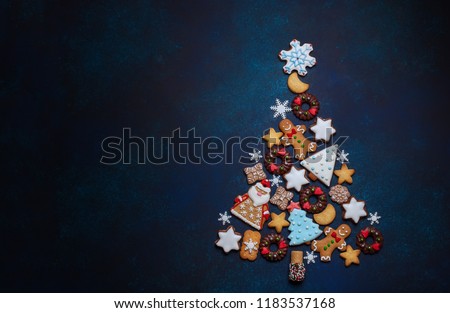 Assorted Christmas cookies in the shape of a Christmas tree on the blue background. Top view.