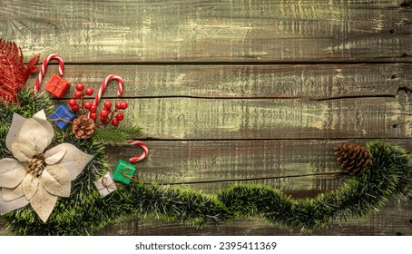 Assorted Christmas decorations including a festive wreath, pine cones, and candy canes on an aged wooden surface. - Powered by Shutterstock