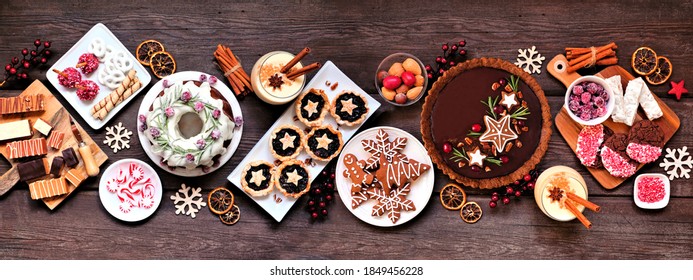 Assorted Christmas holiday desserts and sweets. Top view panoramic table scene over a rustic wood background. Bundt cake, chocolate pie, mincemeat tarts, cookies, fudge and eggnog. - Powered by Shutterstock