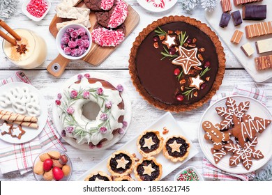 Assorted Christmas holiday desserts and sweets. Top view  table scene over a white wood background. Bundt cake, chocolate pie, mincemeat tarts, cookies, fudge and eggnog. - Powered by Shutterstock