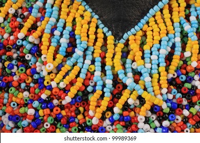 Assorted Colorful Beads As Background For Native American Leather Pouch With Beaded Design.