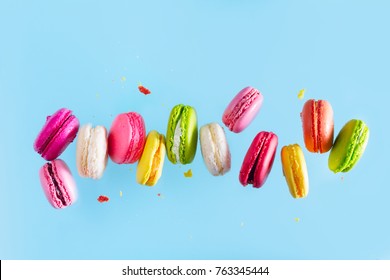 Assorted colorful macaroons falling cookies on blue background - Powered by Shutterstock