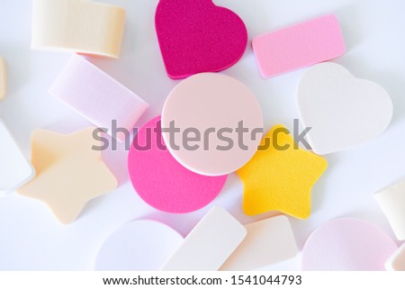 Assorted colorful pastel cosmetic sponges on white background. Beauty concept. Flat lay, top view.