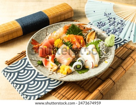 Assorted Comprehensive Sashimi with Dory sashimi, salmon sashimi, Tuna fish, swordfish served in plate isolated on napkin side view on wooden background of Japanese food