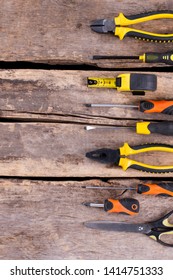 Assorted construction tools on rustic wooden background. Cracked wooden boards with different repair instruments. Top view with copy space.