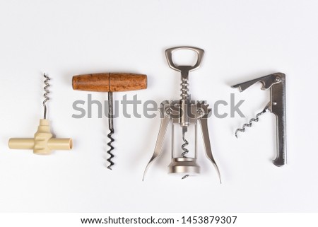 Assorted corkscrews on white. Four different styles of wine openers in a row.
