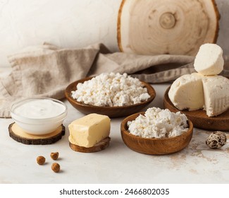 Assorted dairy products including cottage cheese, sour cream, and butter on a rustic wooden setup