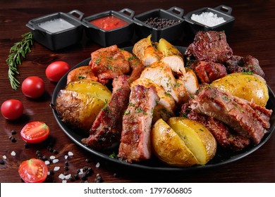 Assorted delicious grilled meat with vegetable. Mixed grilled bbq meat with vegetables. Set of shish kebabs or barbecue shashlik collection. Baked potatoes and fresh tomatoes. Various sauces for meat.