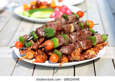 Assorted delicious grilled meat with vegetable on white plate on picnic table for family bbq party - Powered by Shutterstock