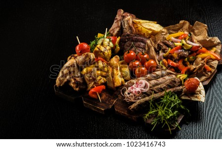 Assorted delicious grilled meat with vegetable. Mixed grilled bbq meat with vegetables. Mixed grilled meat on wooden platter. Copyspace. Stock photo © 