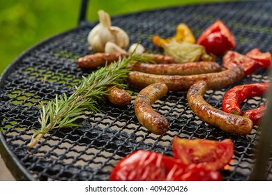 Assorted delicious grilled sausages with vegetable over the coals on a barbecue