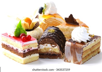 Assorted different mini cakes with cream, chocolate and berries