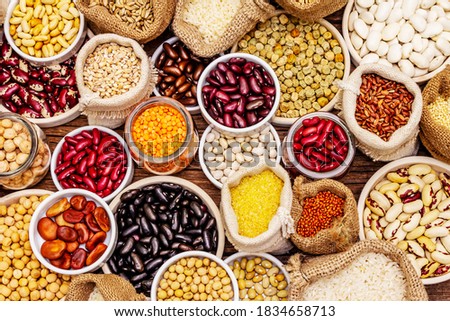 Assorted different types of beans and cereals grains. Set of indispensable sources of protein for a healthy lifestyle. Old wooden tableб top view