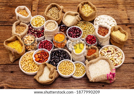 Assorted different types of beans and cereals grains. Set of indispensable sources of protein for a healthy lifestyle. Old wooden tableб top view