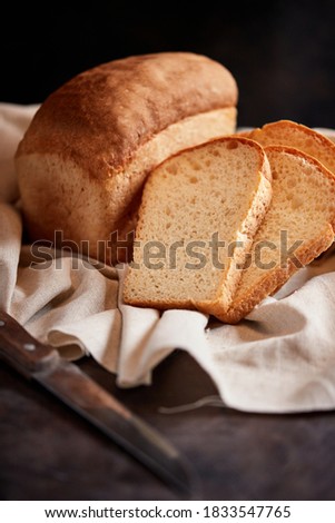 Assorted different types of bread, gluten-free bread, close-up on a dark background. French baguette with sesame seeds. Place for text
